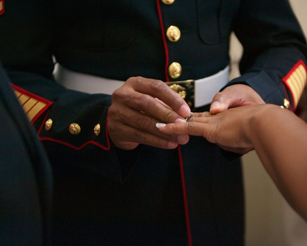 Marine marriage brown hands him putting on her ring